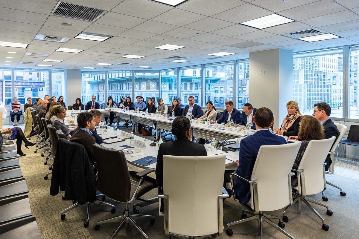 Men and women sit at a conference table discussing environmental, social and governance, or ESG, frameworks at an Financial Freedom forum.